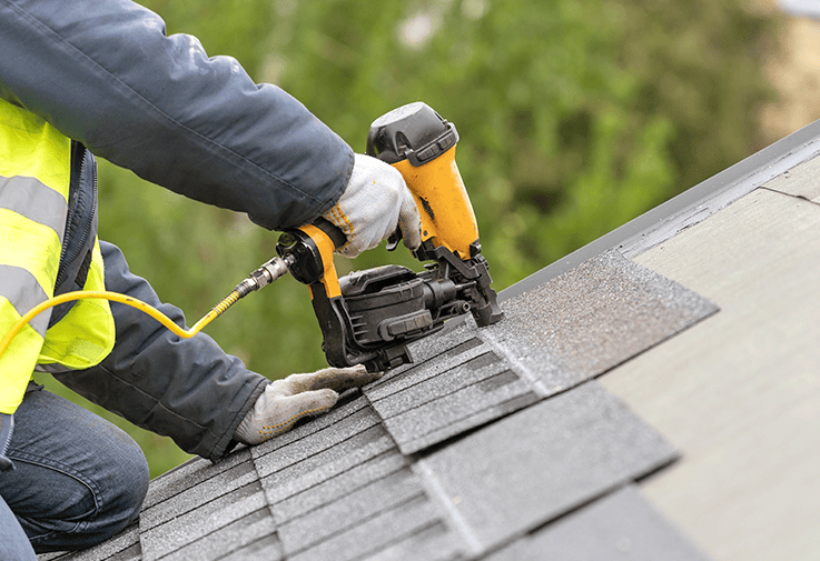 Roofer installing asphalt shingles