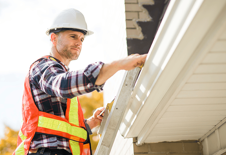 Roofer inspecting house roofline