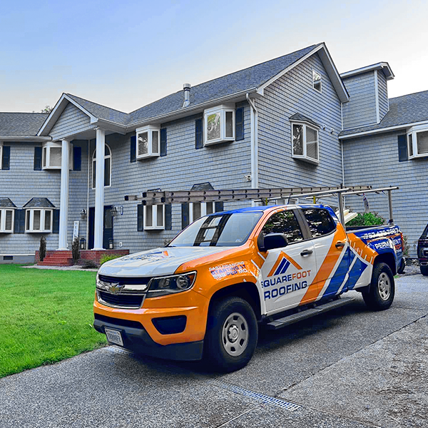 Roofing company truck at house