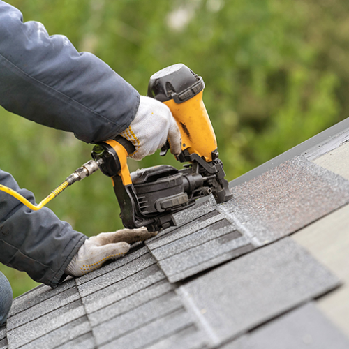Roofer installing asphalt shingles