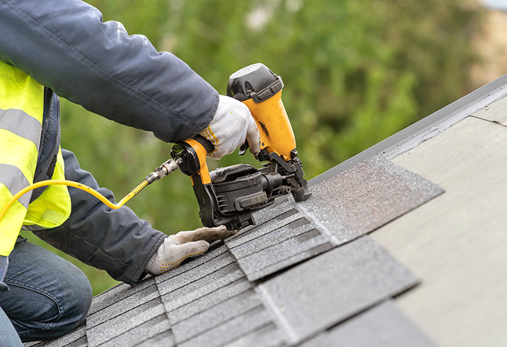 Roofer installing asphalt shingles